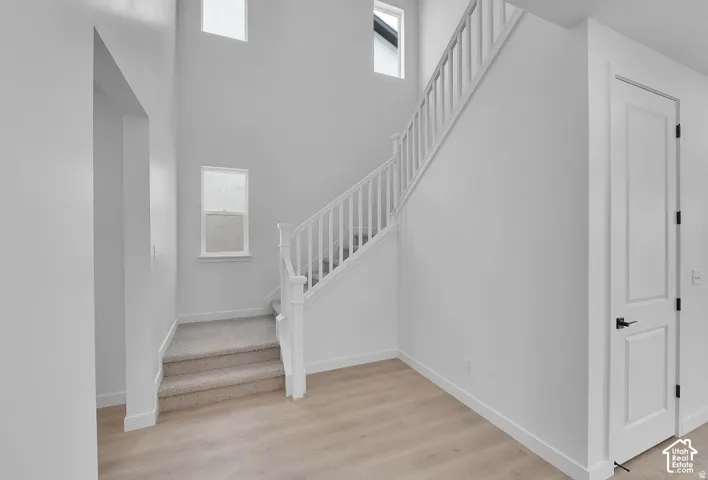 Two-story entryway featuring wood-finish flooring