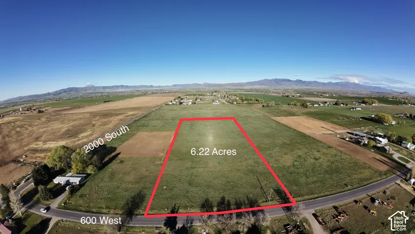 Expansive 6.22-acre parcel with surrounding open fields and a distant mountain range