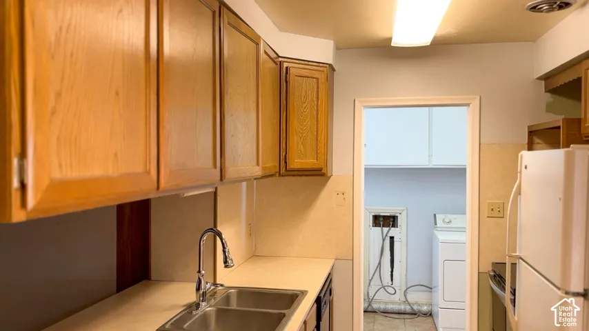 Wood-finish cabinetry paired with a stainless steel double-basin sink and a chrome pull-down faucet