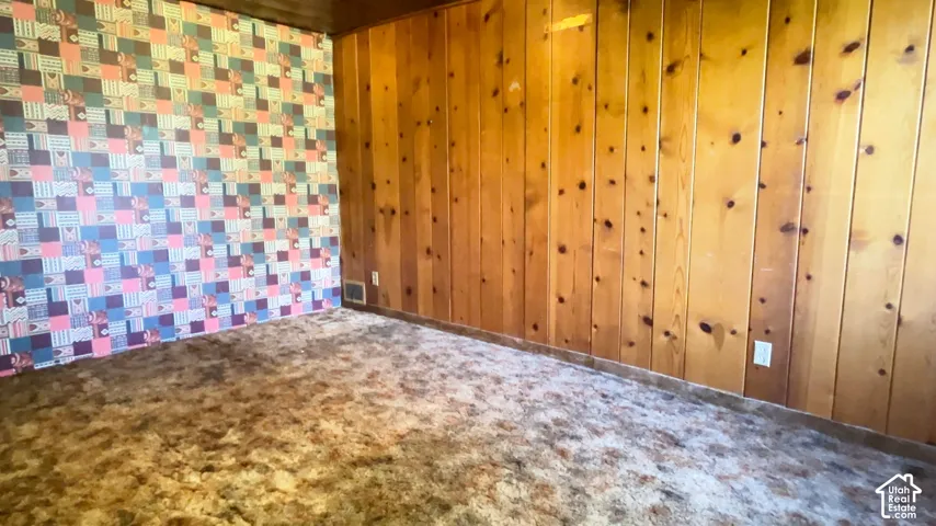 Wood paneling and patterned wallpaper create a distinct interior aesthetic