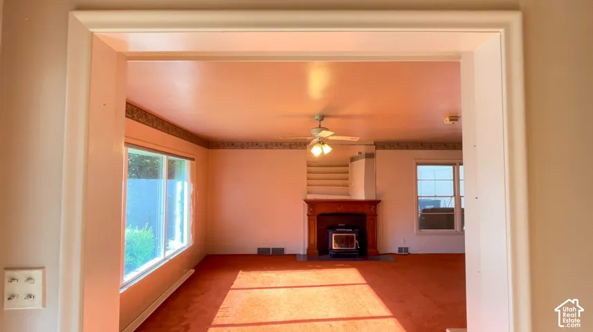 Room featuring a wood-finish fireplace surround, an insert, and a ceiling fan