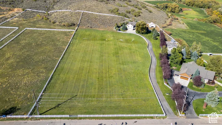 Expansive land parcel with a manicured lawn area and a private paved driveway
