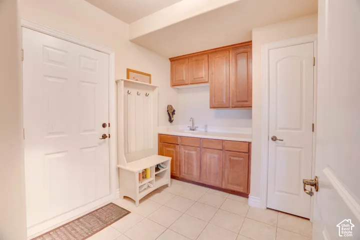 Built-in cabinetry with wood-finish doors, white countertops, and a stainless steel sink