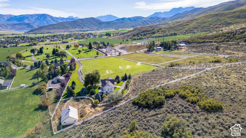 Expansive property featuring a main residence, an additional auxiliary structure, and a winding paved driveway