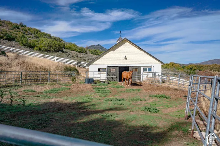 Barn structure featuring a cupola and a weather vane, with a two-tone exterior finish