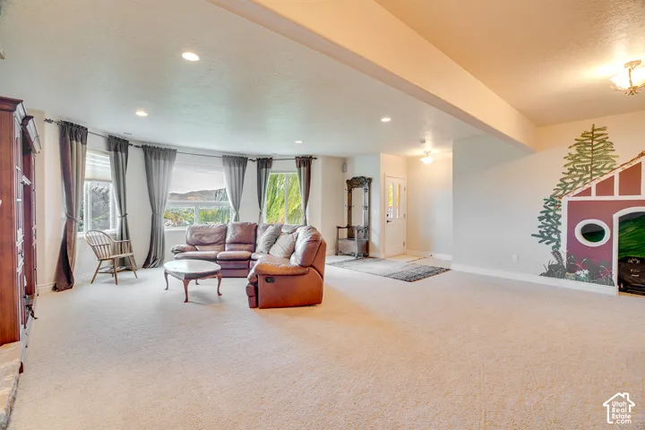 Carpeted living area with recessed lighting, large bay windows, and a built-in wall mural