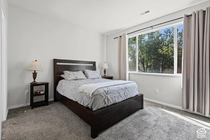 Expansive window with exterior scenery, light gray wall paint, and gray carpet flooring