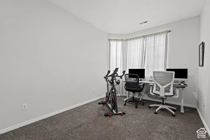 Carpeted room with a bay window, white walls, and a white ceiling