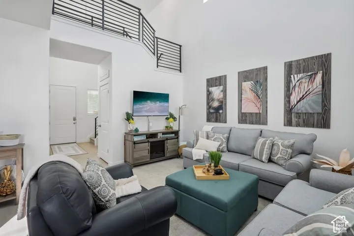 Vaulted ceilings with a loft, metal horizontal-slat railings, recessed lighting, and a wood-finish media console