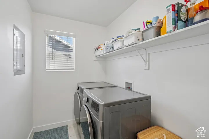 White walls with a window featuring blinds, an upper storage shelf, and tile flooring