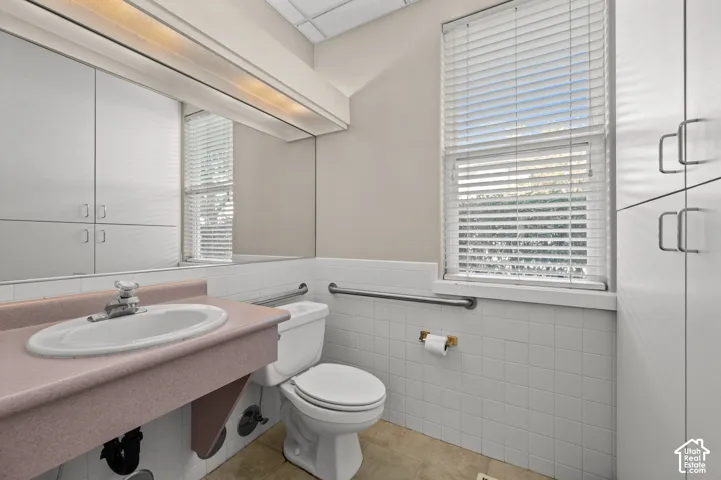 Integrated vanity with basin sink, wall-mounted mirror, and overhead lighting