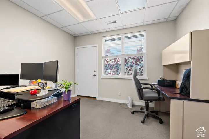 Recessed lighting, wall-to-wall carpeting, window with blinds, light-toned walls, and a built-in desk with upper cabinetry