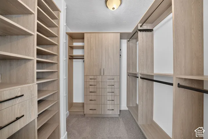 Custom wood-finish closet system with extensive shelving, built-in drawers, and multiple hanging rods