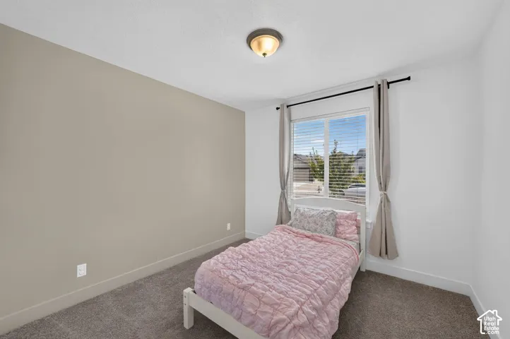 Recessed window with blinds, overhead flush mount light fixture, and carpeted flooring