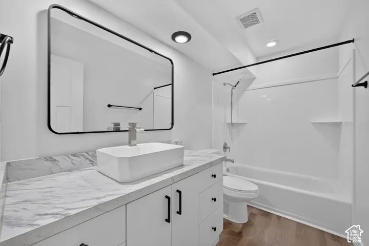 White vanity with black hardware, rectangular vessel sink, and marble-look countertop
