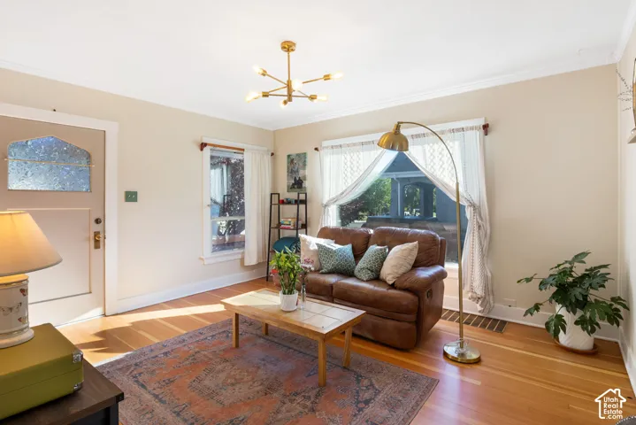 Recently refurbished hardwood flooring throughout living spaces topped with crown molding and modern lighting.
