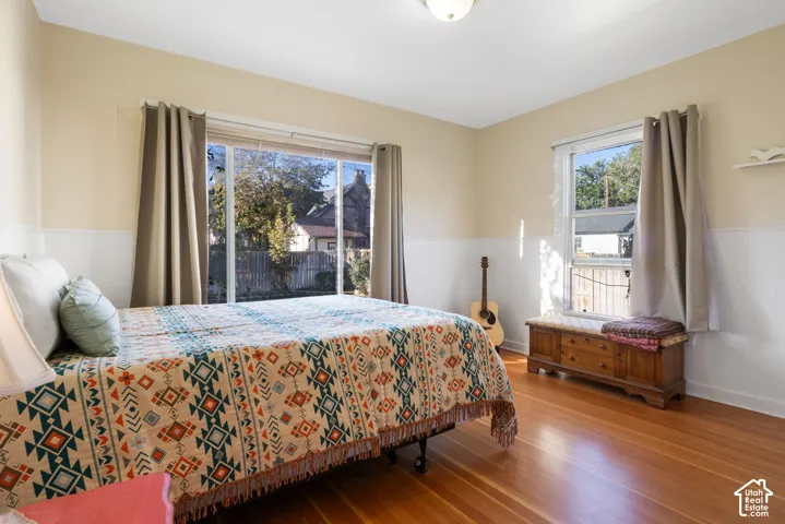 Bedroom 2 with hardwood floors and backyard views.