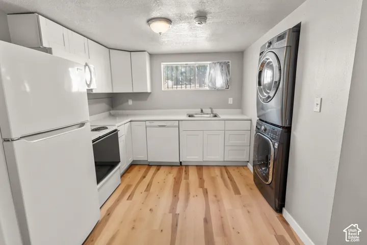 Kitchen featuring white cabinetry, white countertops, built-in dishwasher, and wood-finish flooring