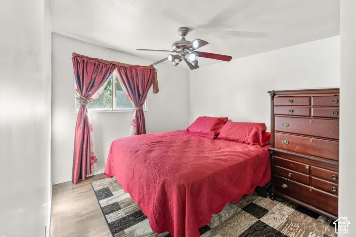 Wood-finish flooring, single window, and a ceiling fan with integrated lighting