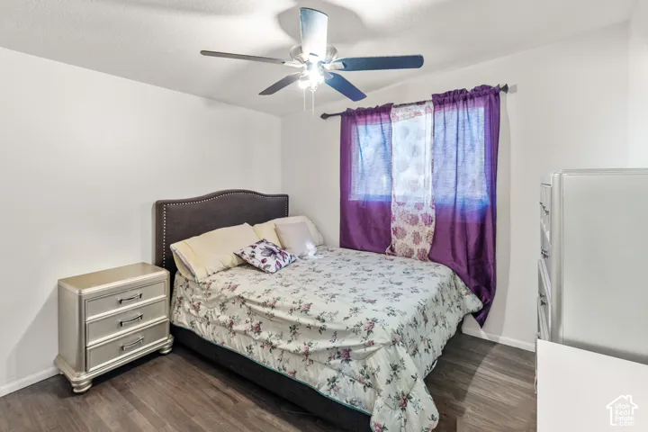 Wood-finish flooring, ceiling fan, and window with natural light