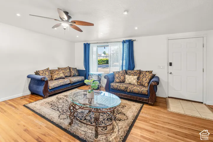 Recessed lighting, ceiling fan, wood-finish flooring, white paneled door, and a tiled entryway