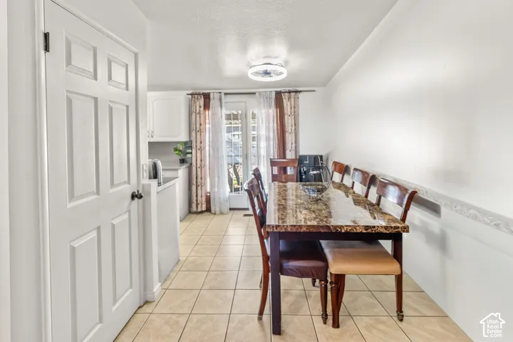 Tile flooring throughout, white paneled door, ceiling-mounted light fixture, white cabinetry
