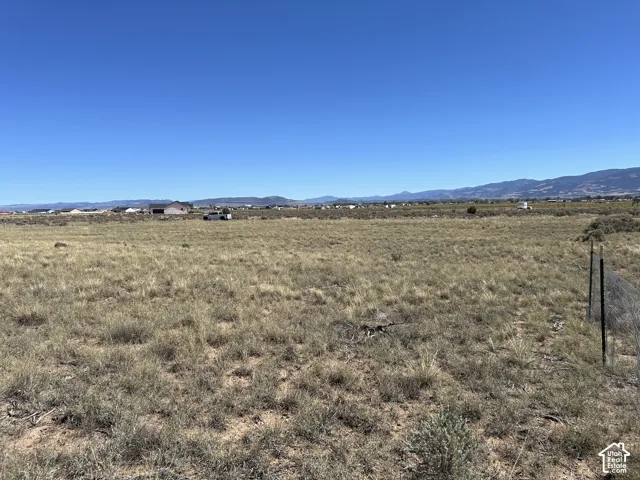 Expansive undeveloped land featuring natural vegetation and distant mountain ranges