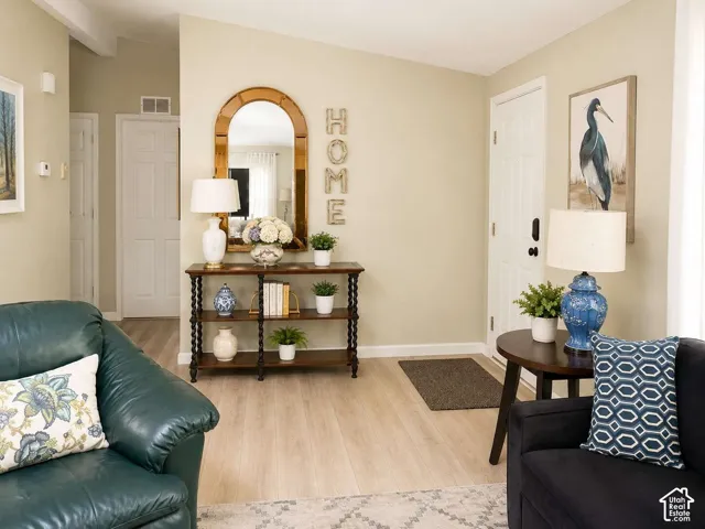 Light wood-finish flooring, vaulted ceiling, and white interior doors
