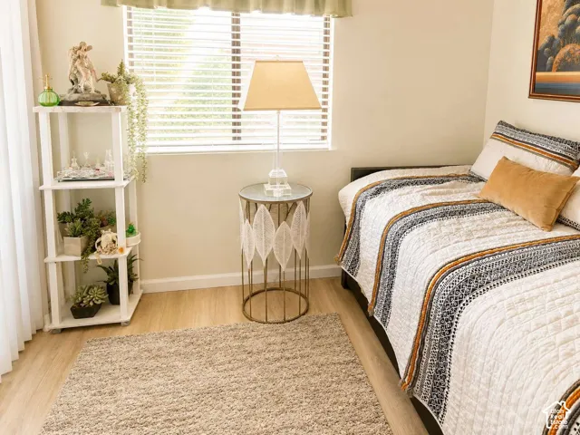 Neutral wall color, wood-finish flooring, white window blinds, and a built-in shelving unit