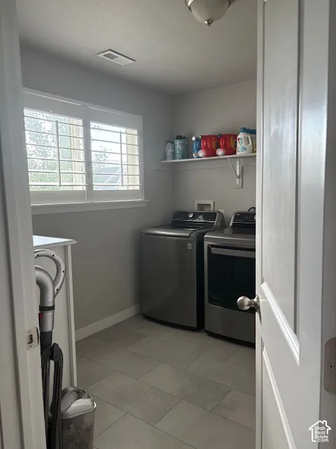 Window with white blinds, wall-mounted shelving, overhead lighting, and tiled flooring