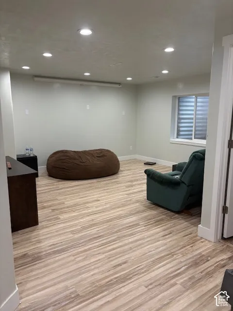 Recessed lighting, wood-finish flooring, and a window with blinds