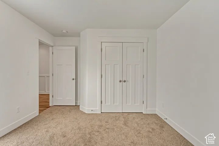 Neutral-toned carpeting, white walls, and white trim