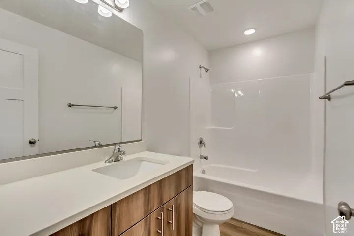 Vanity with a light-toned countertop, wood-finish cabinetry, and a chrome faucet