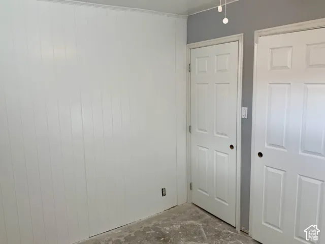 White vertical paneling, two paneled doors, and track lighting
