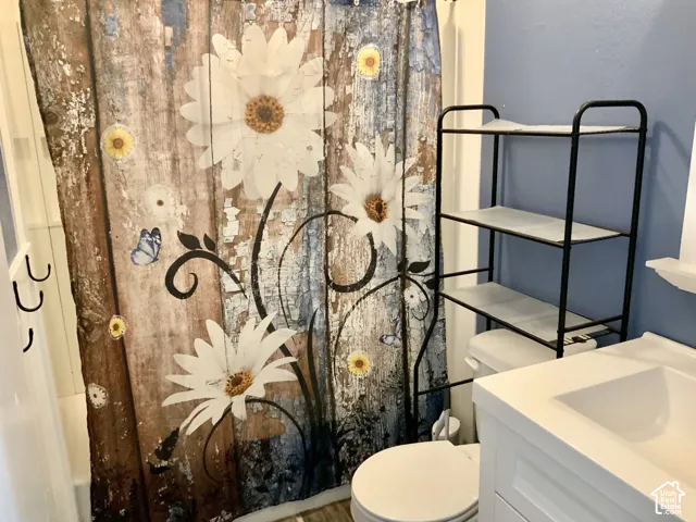 White vanity with integrated sink, white toilet, and light blue wall finish