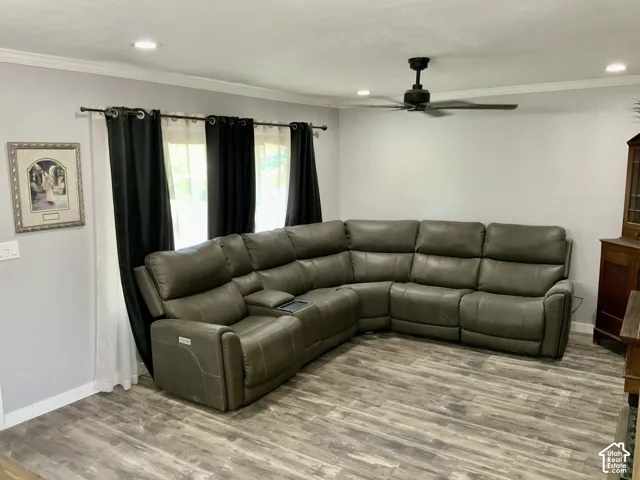 Wood-finish flooring, recessed lighting, ceiling fan, crown molding, and light-toned walls