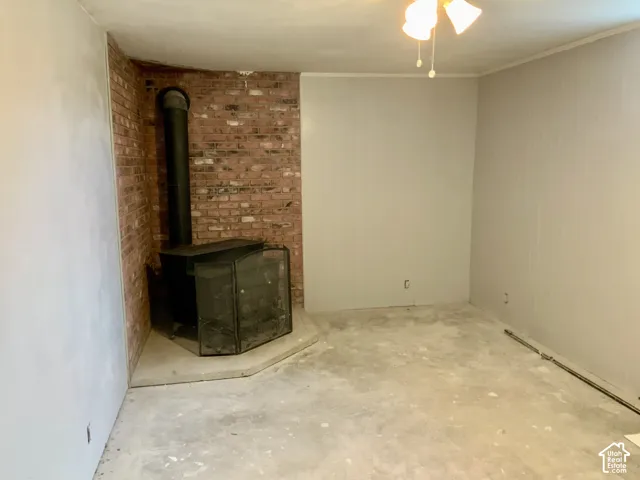Brick accent wall with a wood-burning stove and a concrete hearth