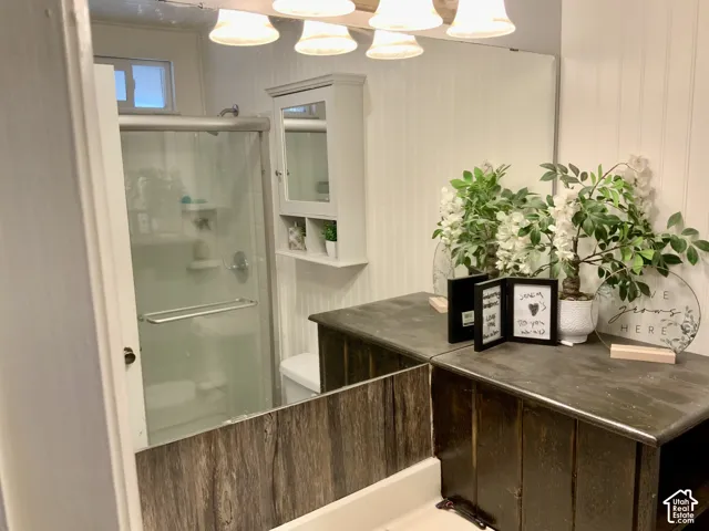 Glass-enclosed shower with chrome fixtures