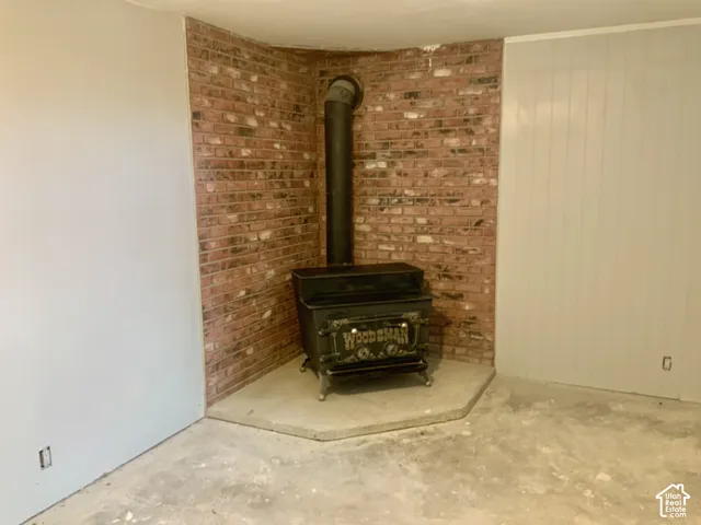 Brick accent wall with a wood-burning stove and concrete hearth