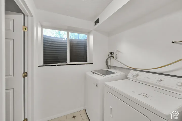 Window with pleated blinds, light-toned walls, and diamond pattern floor tiles