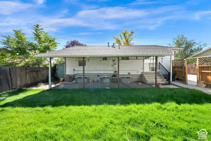 Expansive backyard with a covered patio, concrete pad, and mature perimeter fencing