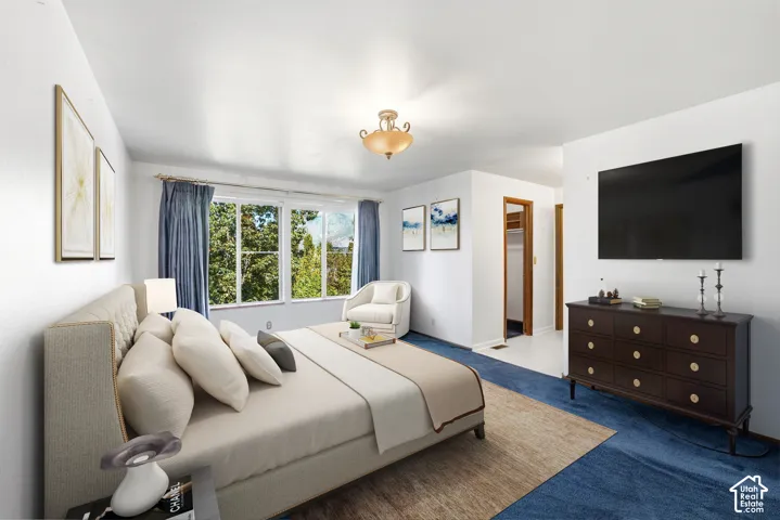 Expansive window with exterior foliage, wall-mounted television, and a built-in closet with wood-finish trim