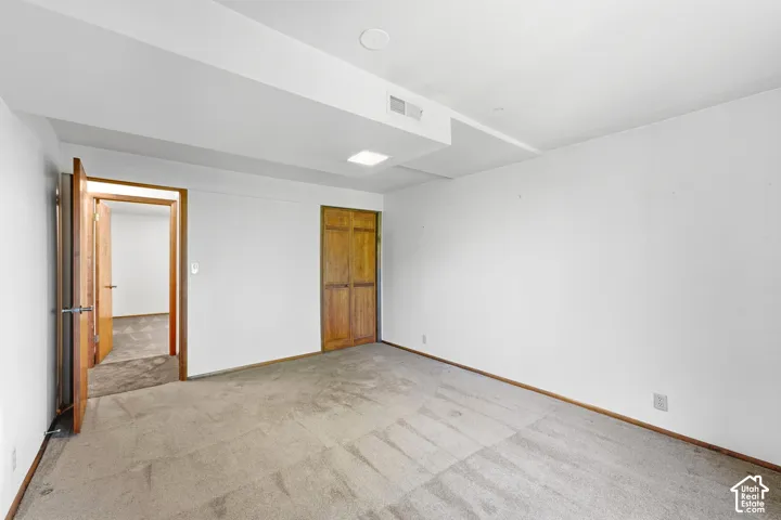 Recessed lighting, wood-finish doors, carpeted flooring, and a built-in closet