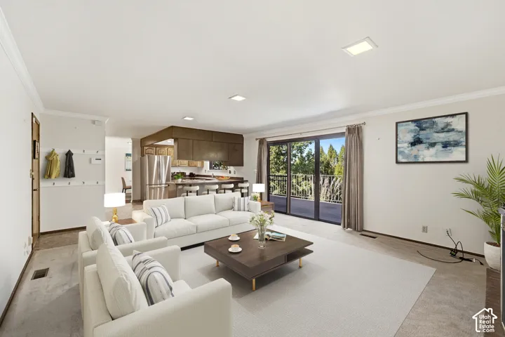 Open-concept living space with recessed lighting and crown molding