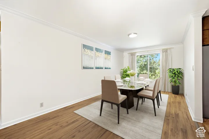Wood-finish flooring, crown molding, and a large window with natural light