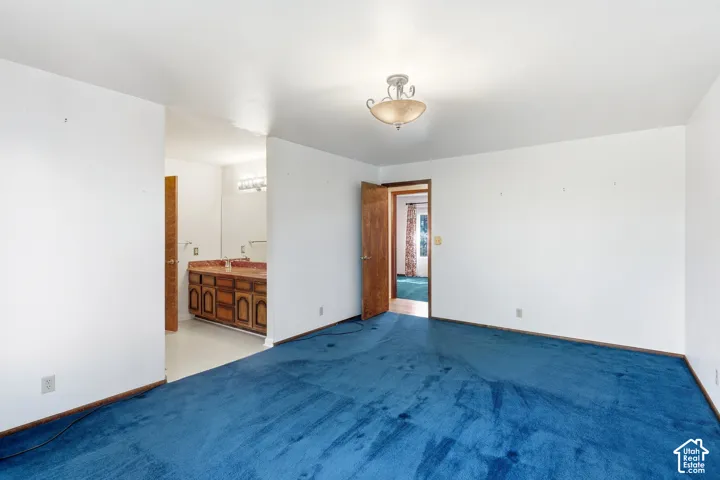 Spacious interior with blue carpeting and white walls