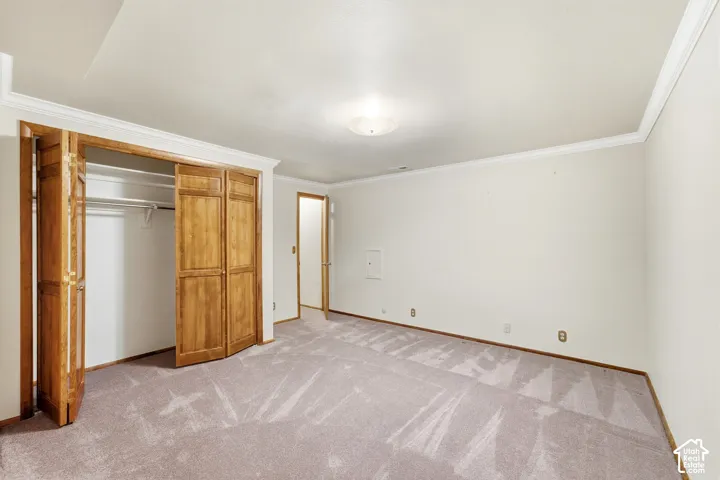 Recessed closet with bi-fold doors, white interior walls, and light-colored carpeting