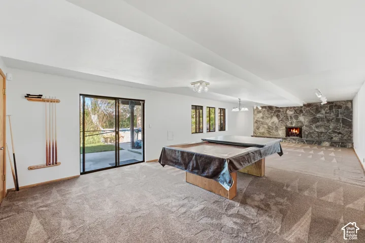 Spacious room with a stone-clad fireplace and sliding glass doors