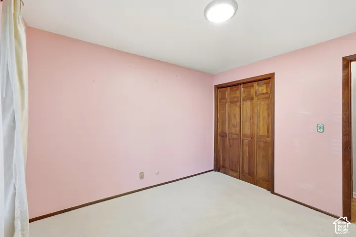 Wall-to-wall carpeting and neutral pink wall finish