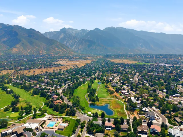 Expansive golf course setting with mountain backdrop and mature trees